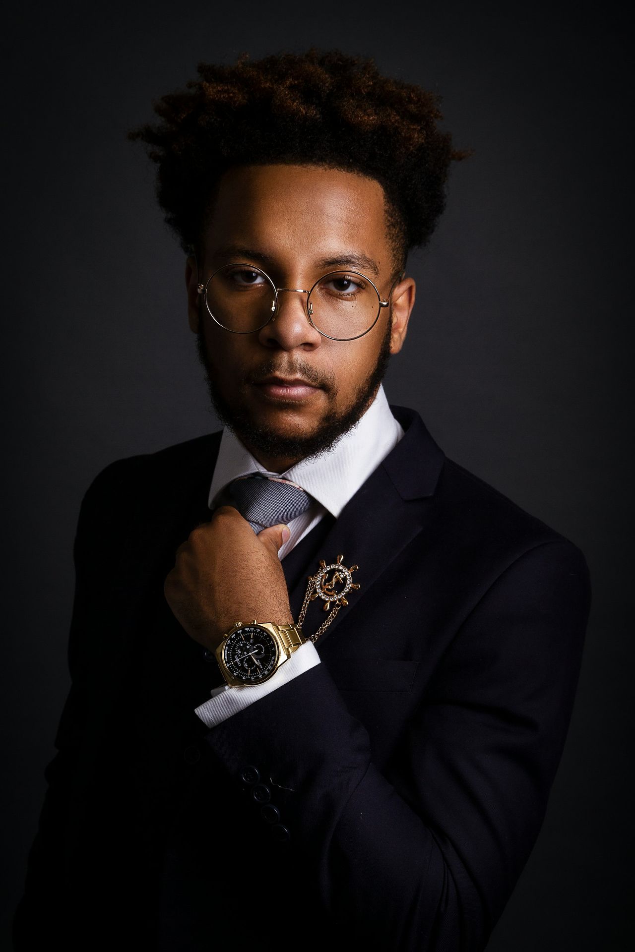 a man in a suit and tie with a watch on his wrist
